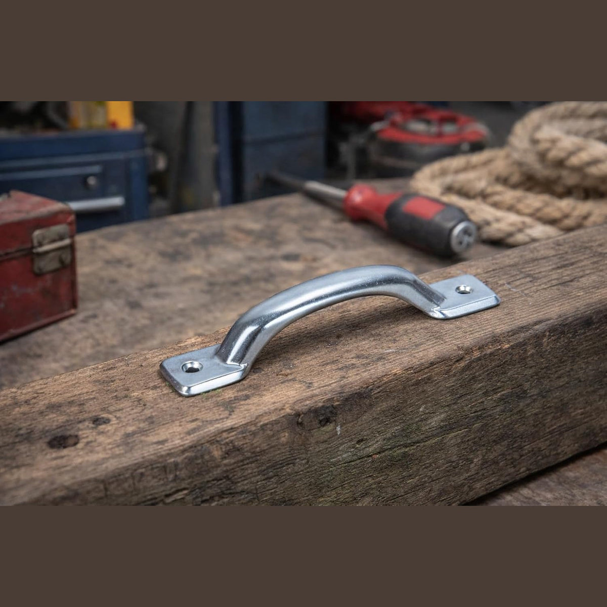 Dettaglio di maniglie per mobili interasse 100 mm Minutex 699 in metallo lucido montate su legno.